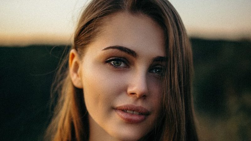 smiling woman wearing white and black pinstriped collared top