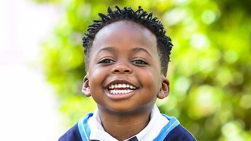 selective focus photo of boy standing on grey pavement